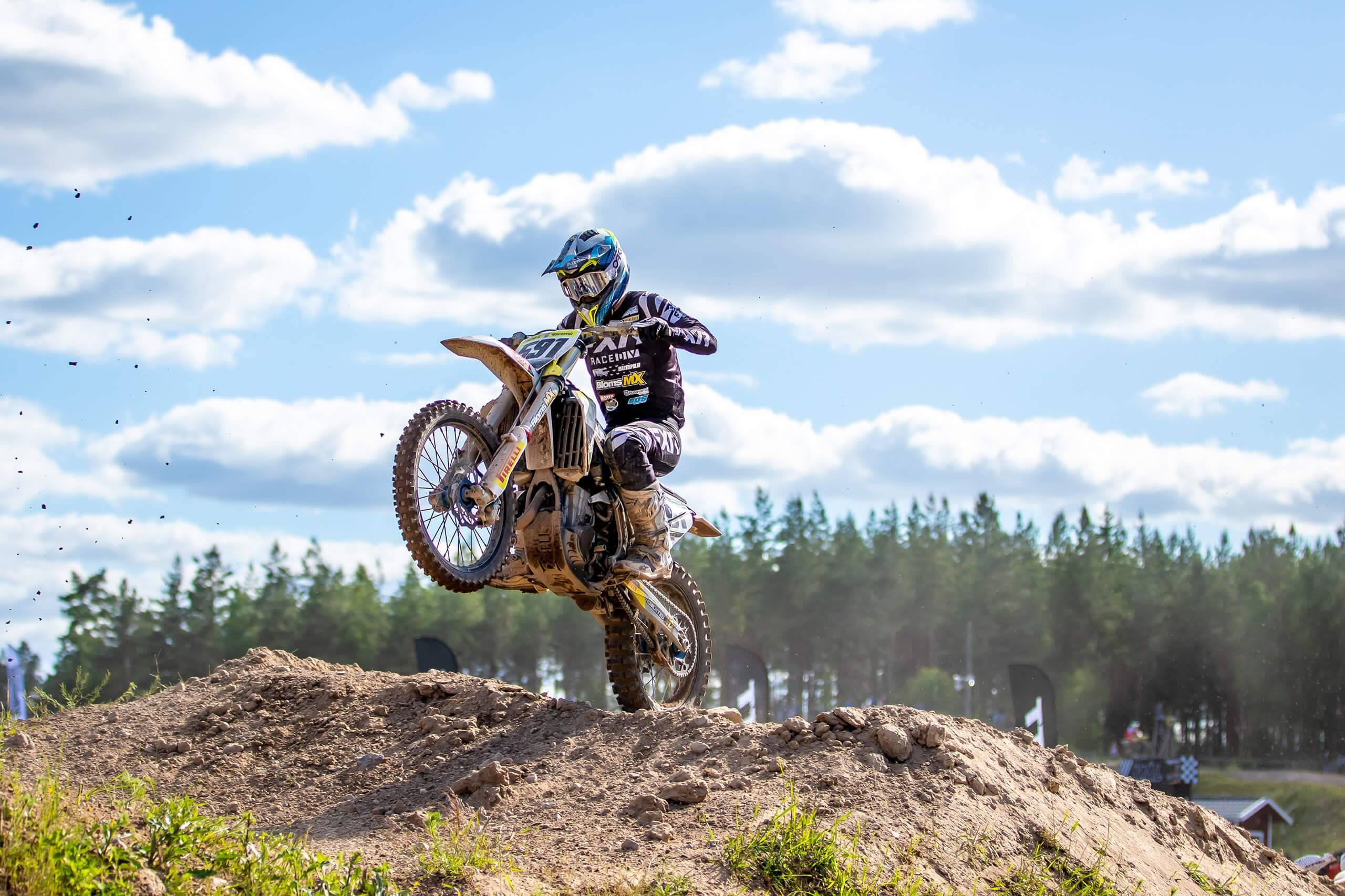 En motocrossförare kommer över ett hopp på bakhjulet