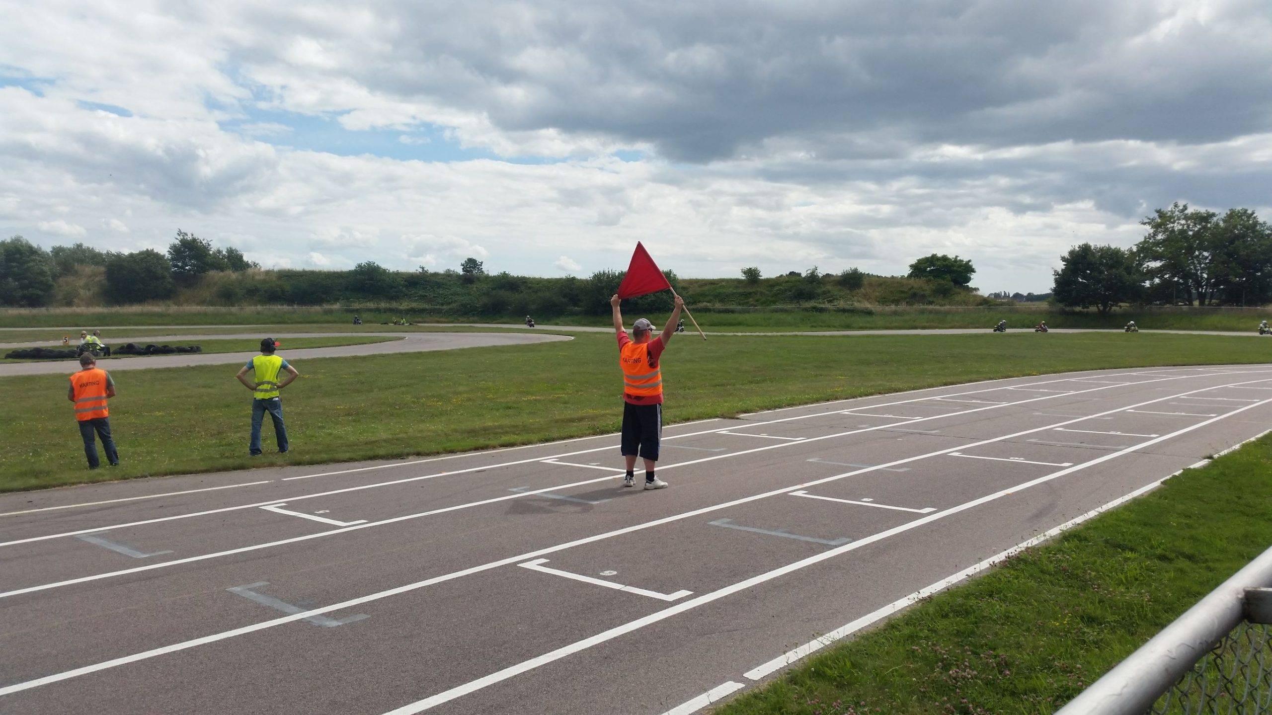 En funktionär visar en röd flagga för att göra förarna uppmärksamma