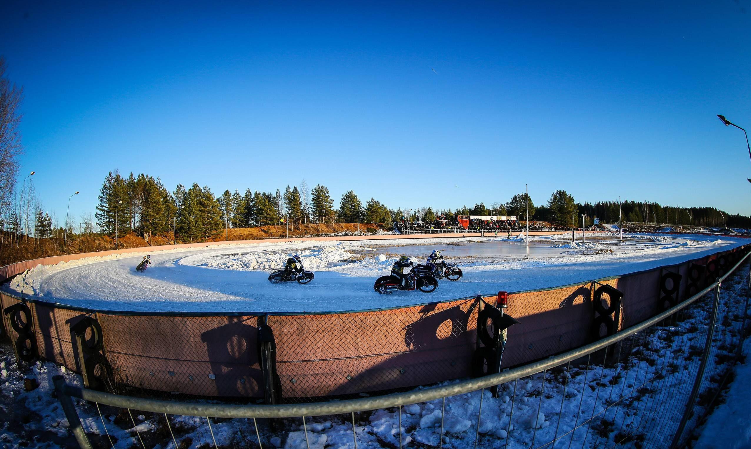 En bild över en isracingbana där man kan se fyra förare åka på varsin isracinghoj.
