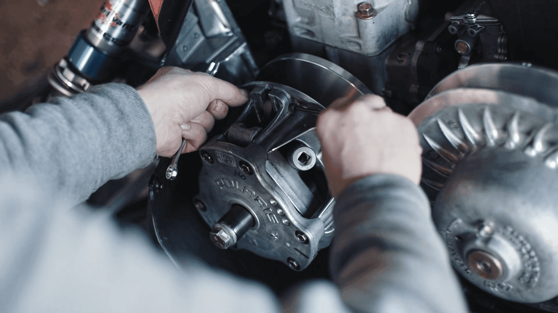 Två händer som mekar med en motor