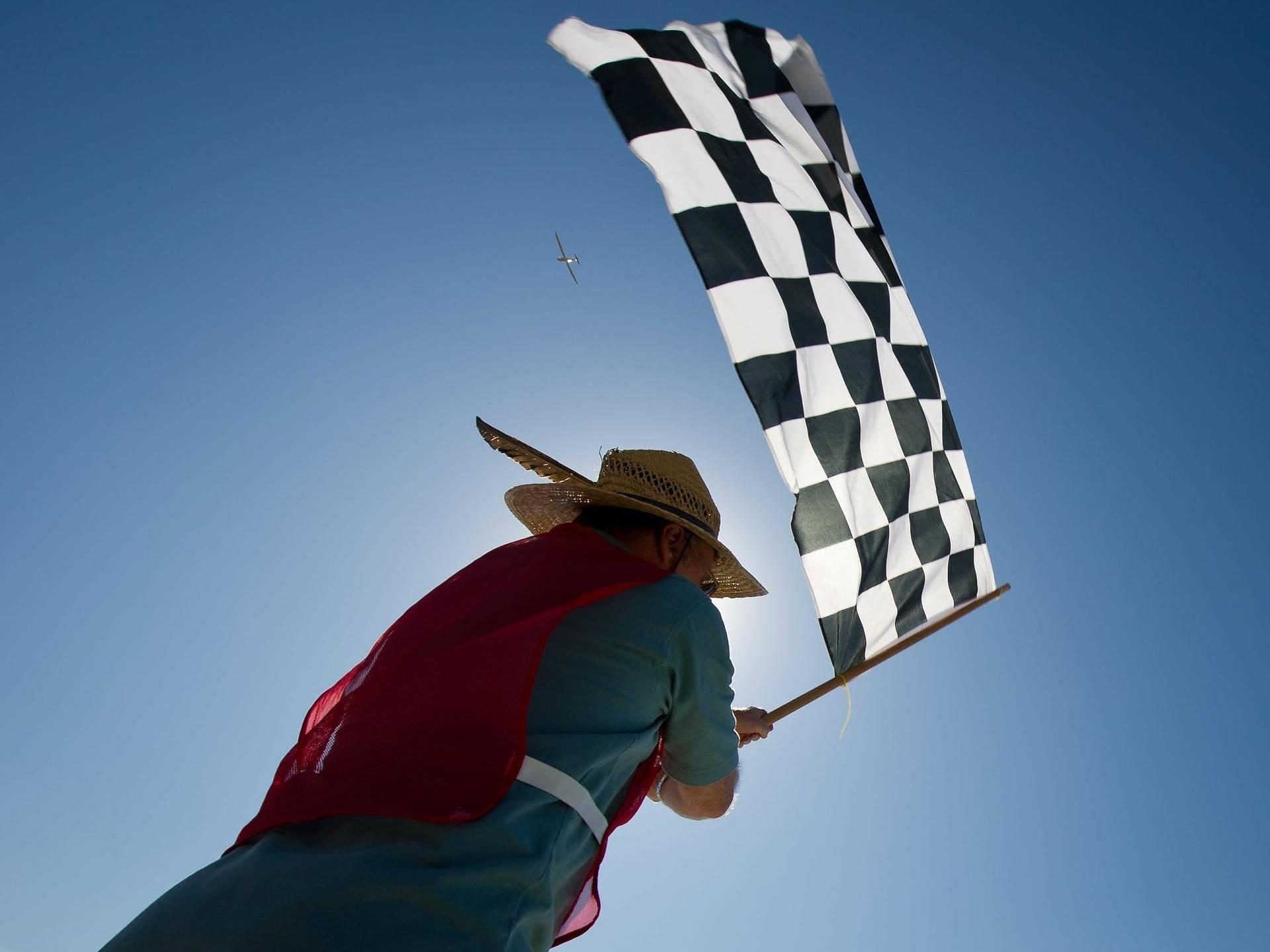 En man håller upp en målflagga i solen