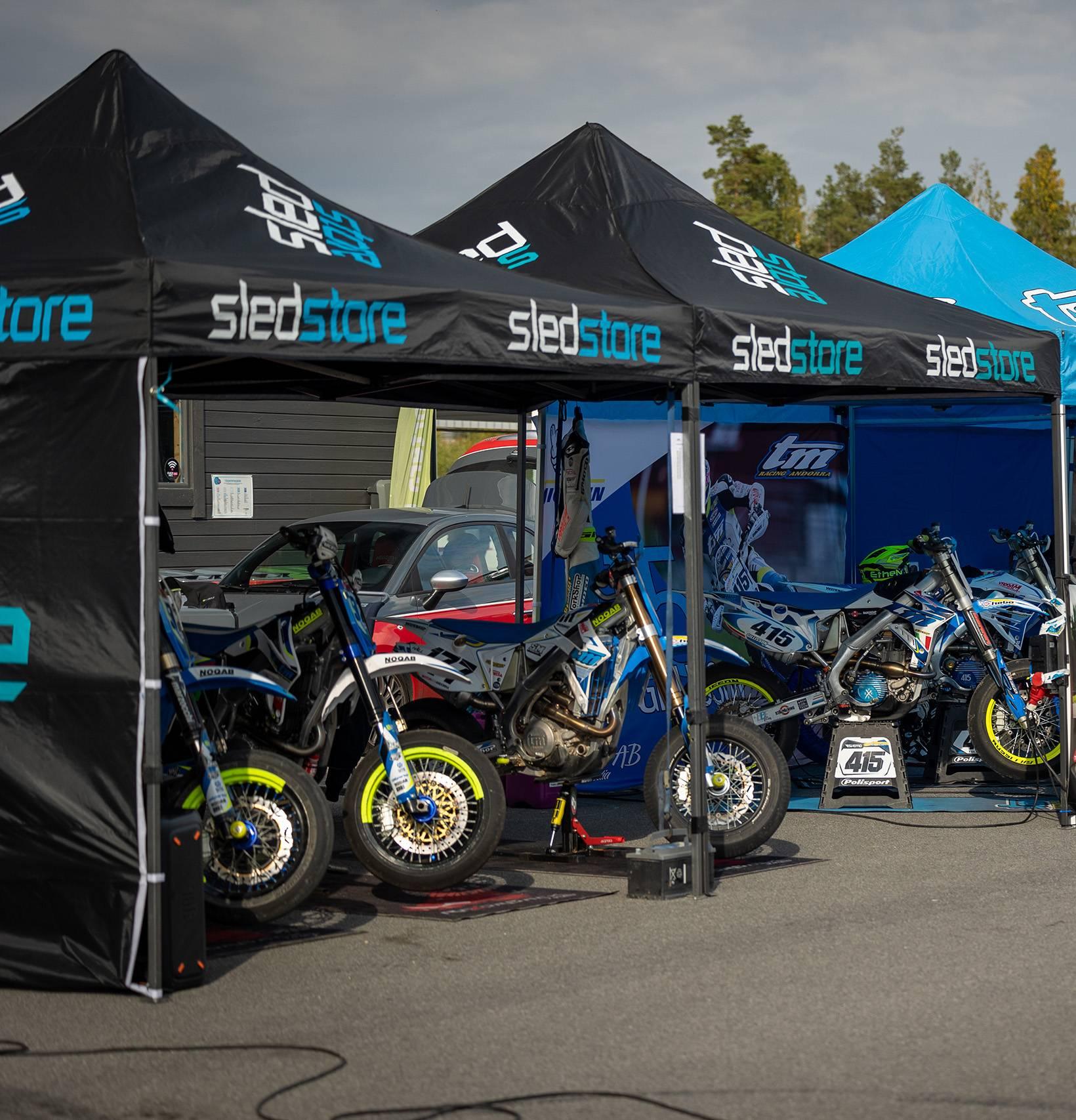 Fyra supermoto hojar står under tälttak på varsinn miljömatta. Fotograf: Maeva Sponbergs