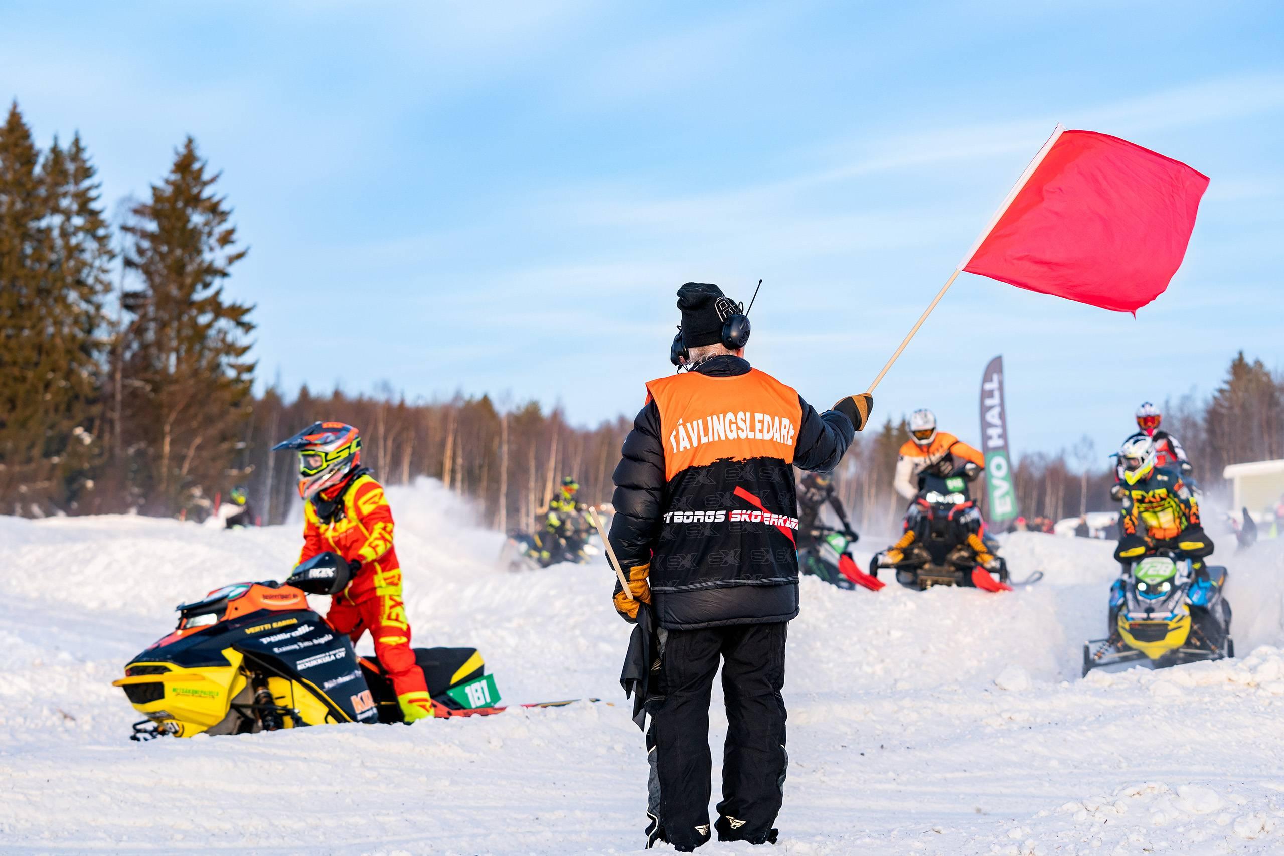 En funktionär som håller upp en rödflagg