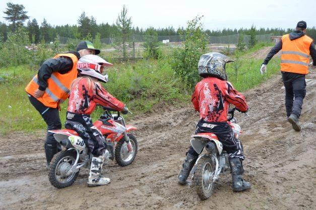 Barn provar på motocross med ledare