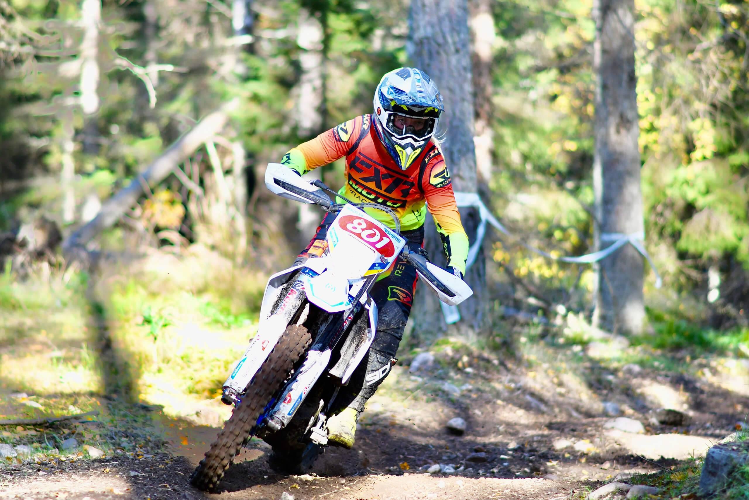 En kvinnlig enduroförare på sin enduro i skogen