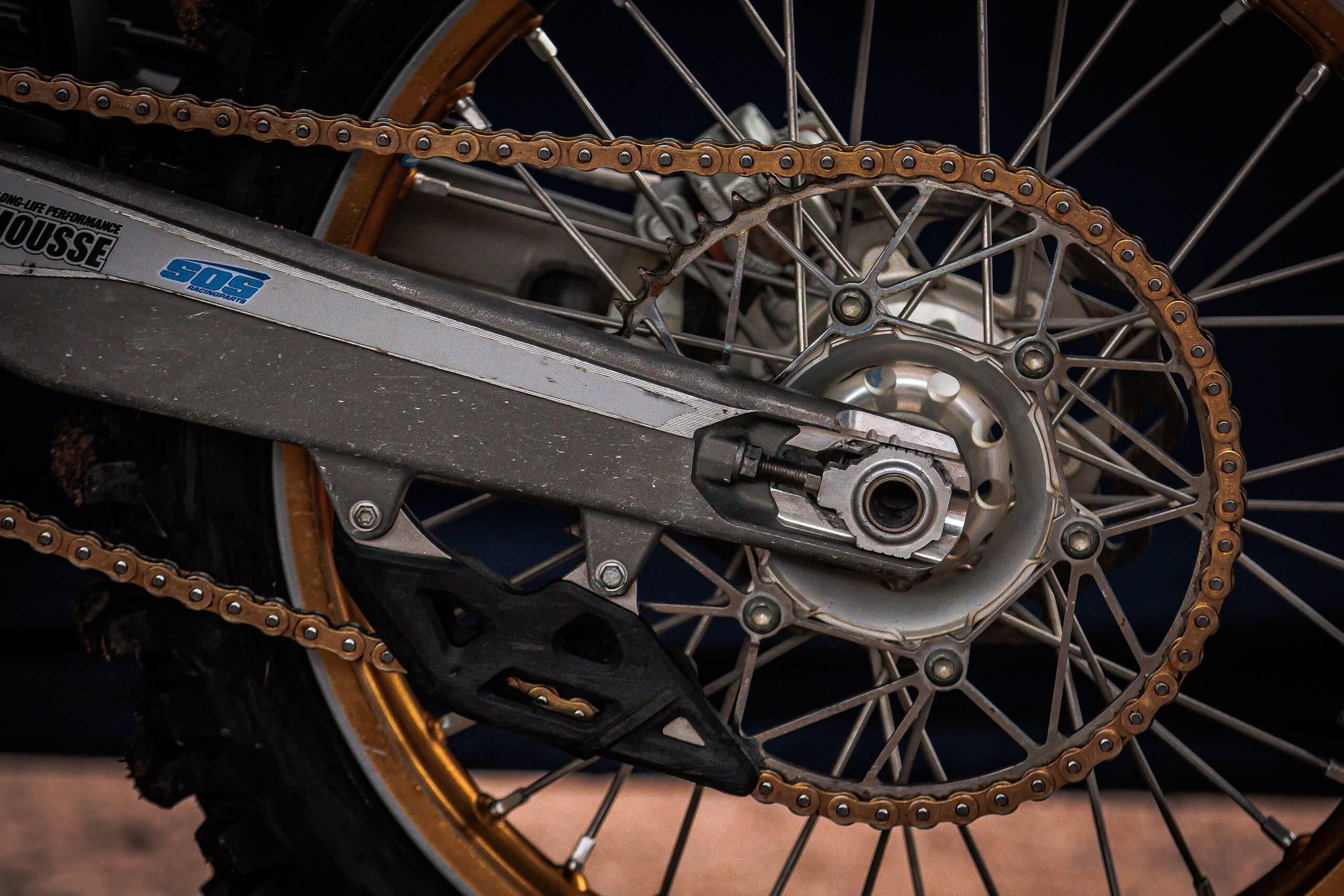 Ett backdäck, fälgar och kedjan på en motocross