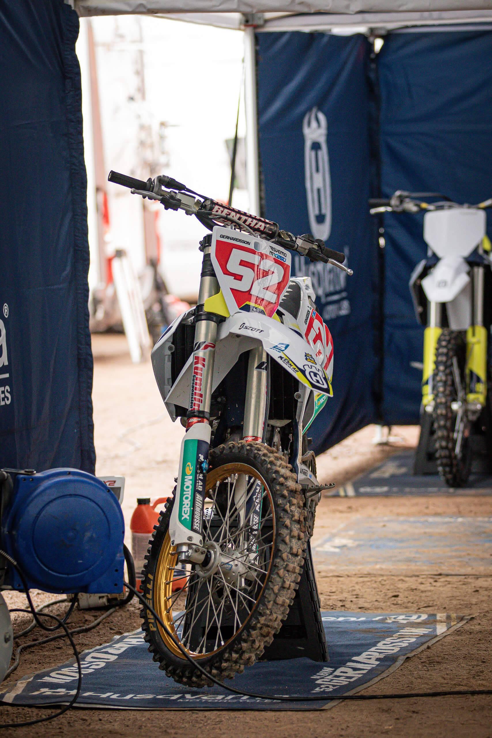 En motocross som står parkerad på en miljömatta i ett tält