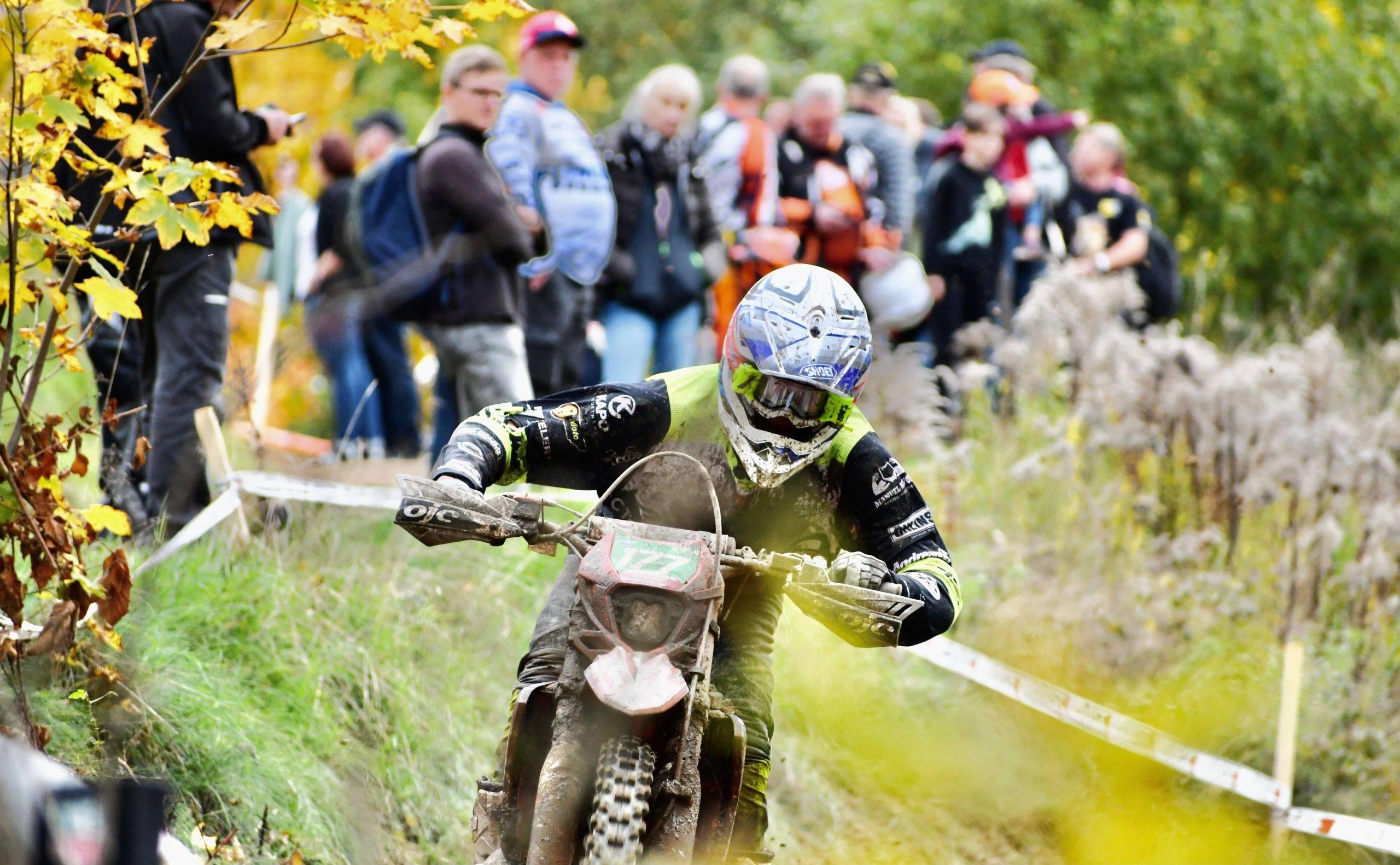 En enduroförare kör på endurobana i utkanten av ett skogsparti