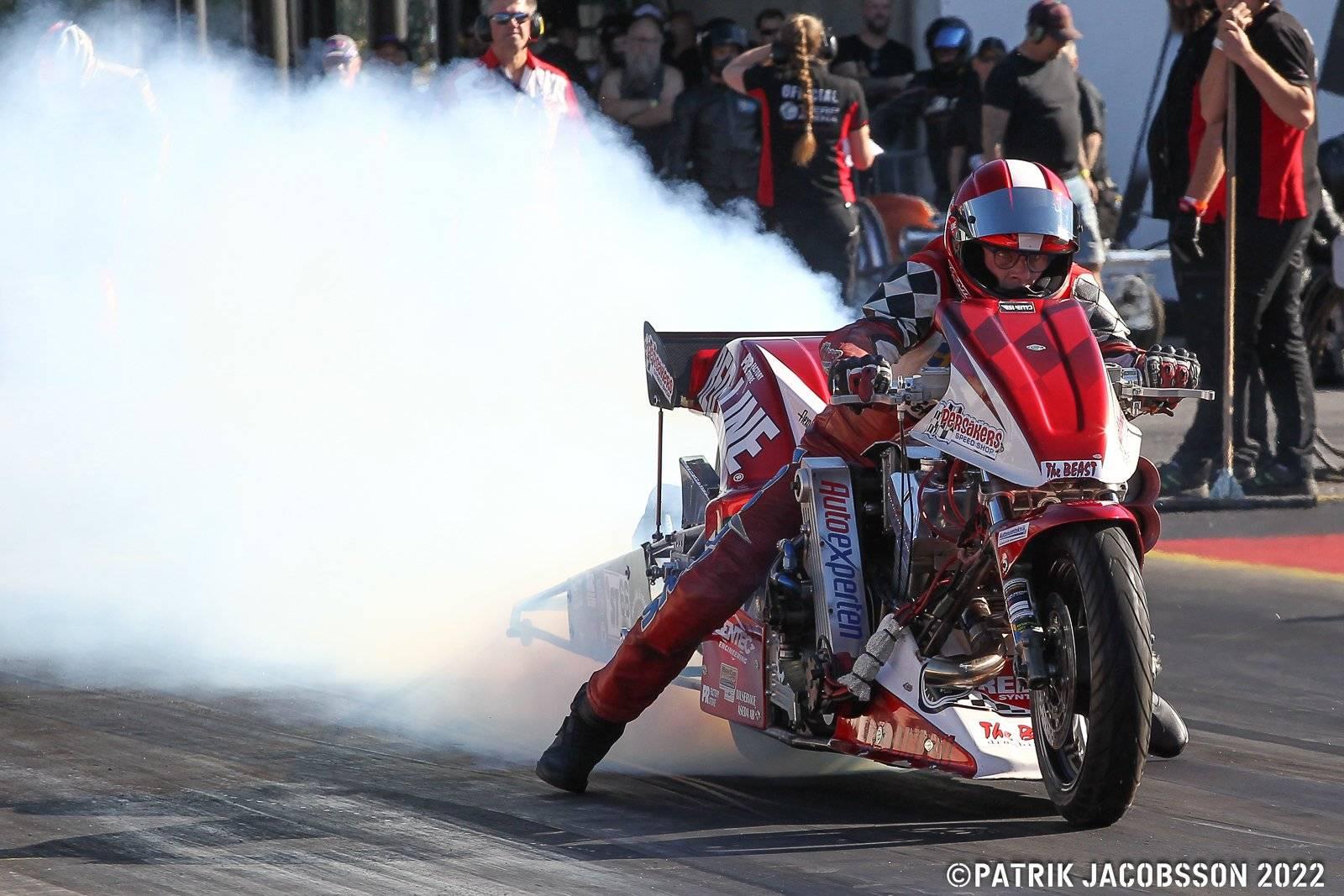 En förare på en röd dragracing-hoj i starten på EM 2022.