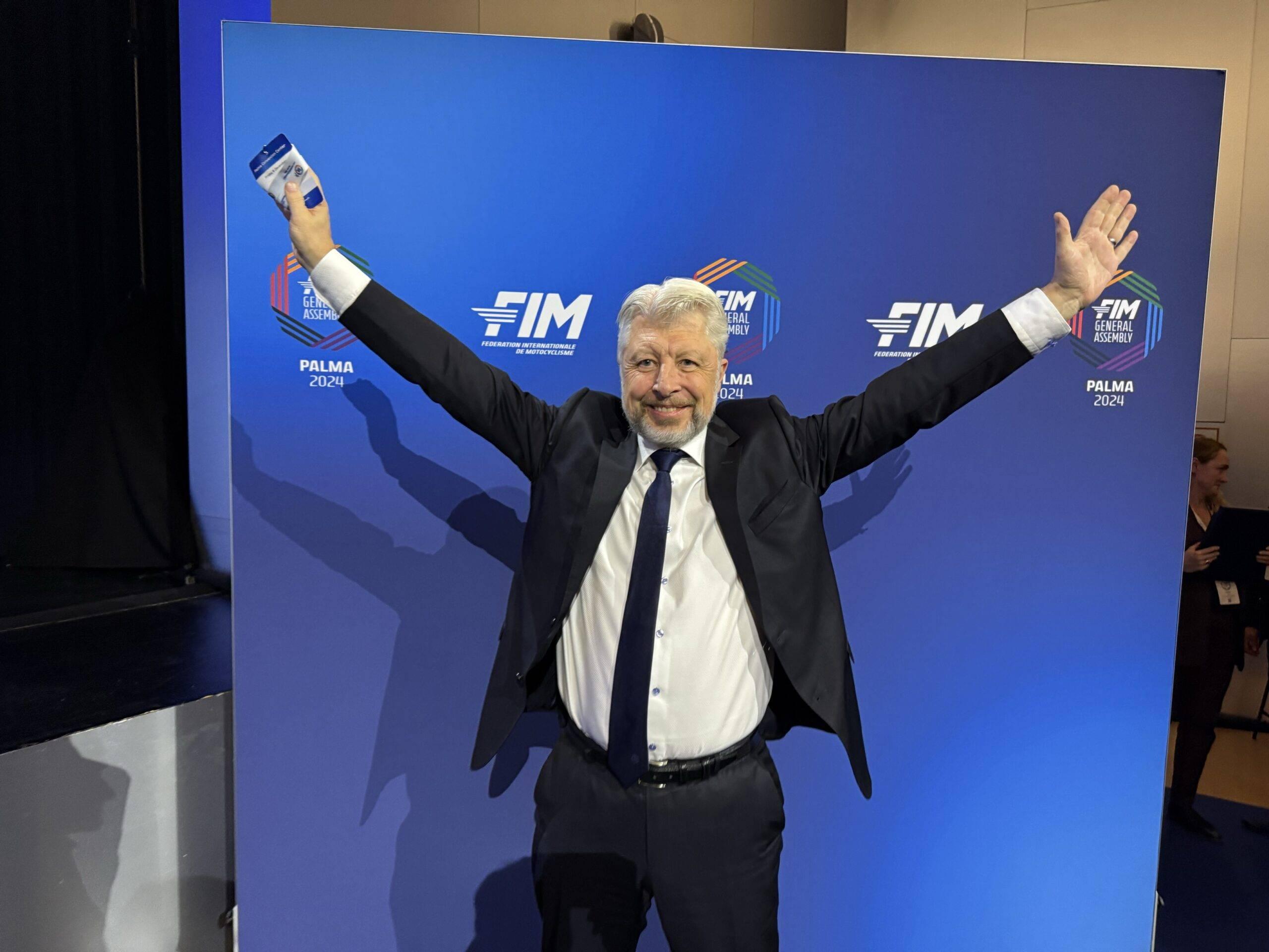 Håkan Leeman poserar med en segerpose framför en FIM-backdrop